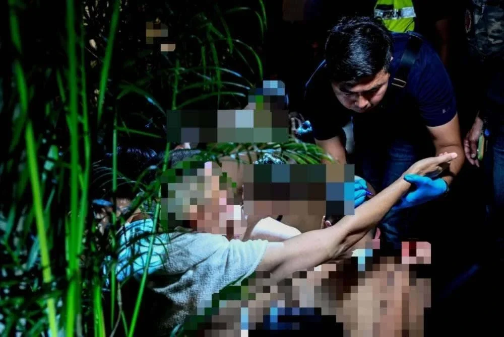 Pegawai penguat kuasa memeriksa salah seorang individu yang ditahan. Foto: Bernama