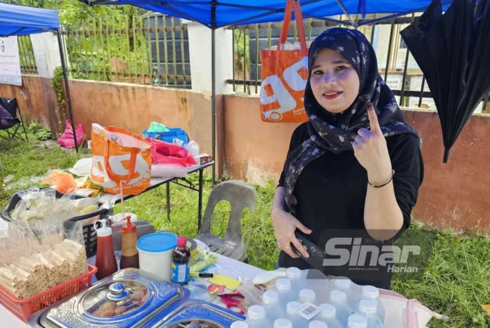 Rozaini menunjukkan jarinya sebagai bukti beliau telah menjalankan tanggungjawab sebagai pengundi dan dalam masa sama mengambil peluang berniaga di luar pekarangan pusat undi di SK Kawang, Papar.