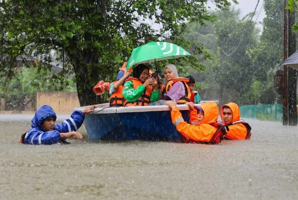 APM melakukan kerja-kerja menyelamatkan mangsa banjir di Kampung Beladau Selat, selepas kawasan itu ditenggelami banjir berikutan hujan lebat. - Foto Bernama