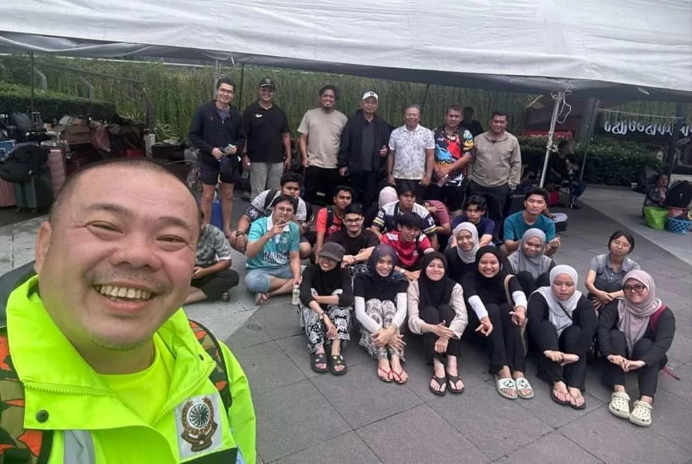 Beng Tat bersama pelajar Universiti Utara Malaysia yang terkandas di Hatyai sebelum dibawa pulang.