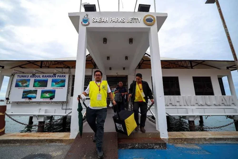 Petugas SPR membawa peti undi keluar dari Pulau Sepanggar menggunakan bot di Sabah Parks Jetty untuk dibawa ke pusat penjumlahan undi. - Foto Bernama 