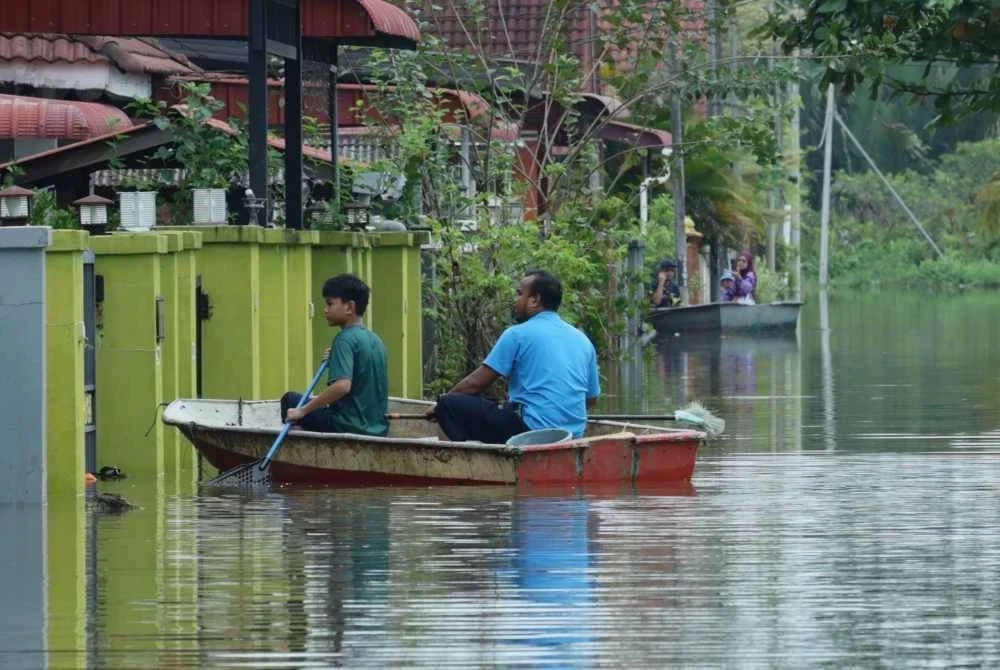 Penduduk dilihat pulang ke rumah bagi mendapatkan barangan peribadi untuk kegunaan di PPS di Taman Desa Setia, Kampung Atas Tol, Kuala Terengganu. - Foto Bernama