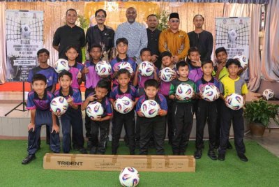 Christopher Raj (tiga dari kiri) bersama Guru Besar SK Bukit Kuchai, Mohammed Salem Fazal Deen (dua dari kiri) bersama murid SK Bukit Kuchai dalam majlis penyerahan sumbangan kelengkapan sukan buat pasukan bola sepak SK Bukit Kuchai.