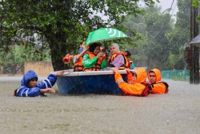 APM melakukan kerja-kerja menyelamatkan mangsa banjir di Kampung Beladau Selat, selepas kawasan itu ditenggelami banjir berikutan hujan lebat. - Foto Bernama 