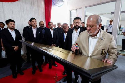 Sultan Ibrahim berkenan menandatangani plak sebagai gimik perasmian Maharani Freeport sambil diperhatikan oleh Pemangku Sultan Johor, Tunku Mahkota Ismail (dua dari kanan) di Kompleks Maharani Energy Gateway (MEG), Tanjung Emas pada Sabtu. - Foto Bernama 