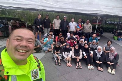 Beng Tat bersama pelajar Universiti Utara Malaysia yang terkandas di Hatyai sebelum dibawa pulang.