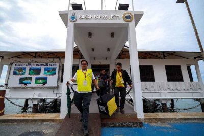Petugas SPR membawa peti undi keluar dari Pulau Sepanggar menggunakan bot di Sabah Parks Jetty untuk dibawa ke pusat penjumlahan undi. - Foto Bernama 