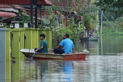 Penduduk dilihat pulang ke rumah bagi mendapatkan barangan peribadi untuk kegunaan di PPS di Taman Desa Setia, Kampung Atas Tol, Kuala Terengganu. - Foto Bernama