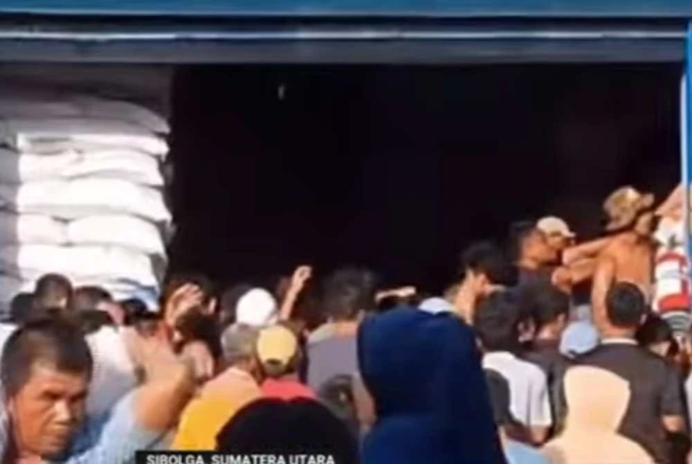 Suasana orang ramai menyerbu gudang simpanan makanan kerajaan untuk mengambil beras. - Foto: Agensi