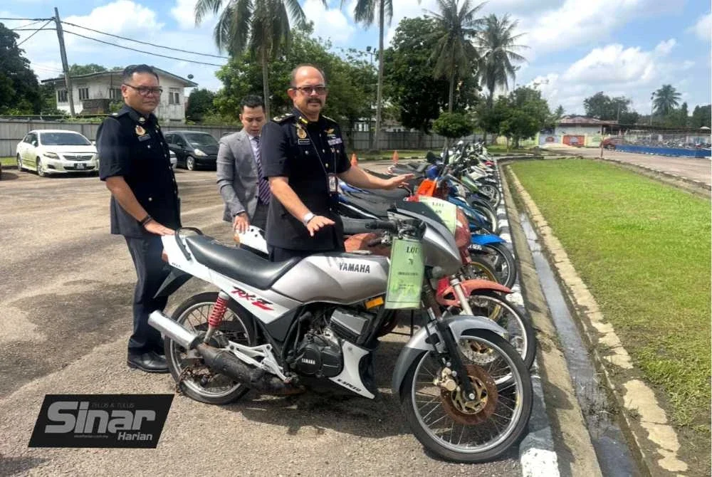 Mohd Misuari (kanan) menunjukkan motosikal Yamaha RXZ yang dibida pada harga paling tinggi bagi kategori motosikal. 