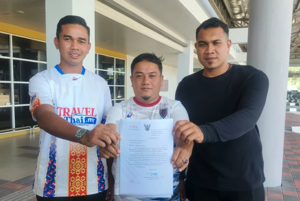 Dari kiri, Ammar Wafiy, Mohd Uzir dan Mohd Akmal Aniq menunjukkan surat kelulusan yang diberikan pihak berkuasa Thailand untuk membawa 15 trak tunda dari Malaysia ke Hatyai.