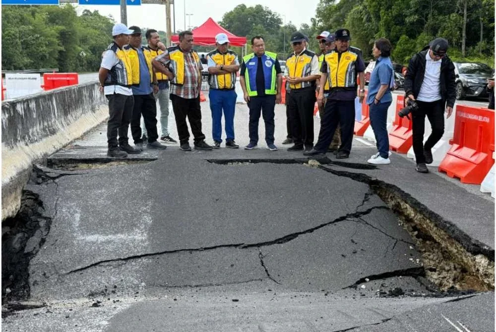 Alexander (enam dari kiri) mendengar penerangan status kerosakan struktur jalan susulan insiden lubang benam berlaku pada malam Sabtu.