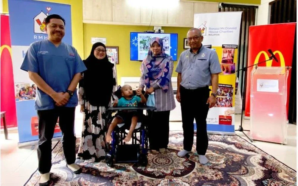 Mohd Nasri (kanan) dan Dr Zaidi (kiri) bergambar bersama keluarga pesakit yang tinggal di Rumah Ronald McDonald, HPUSM, Kubang Kerian, Kelantan.