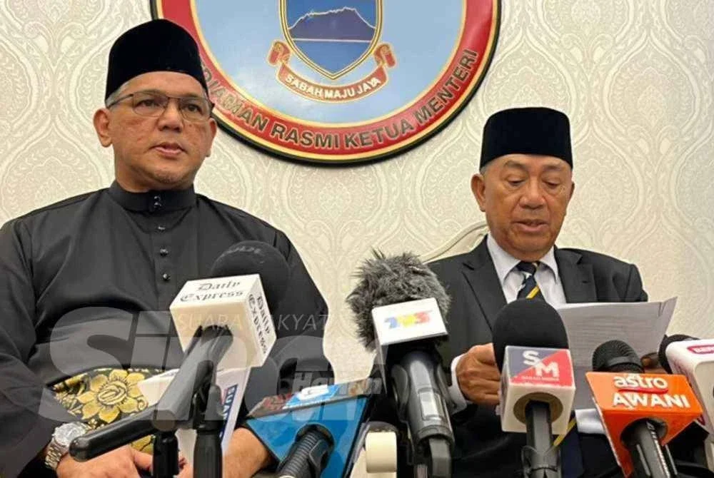 Joachim (kanan) membacakan senarai penuh Kabinet baharu Sabah pada sidang media di Kediaman Rasmi Ketua Menteri, Sri Gaya pada Isnin.