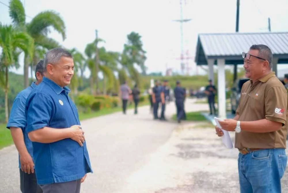 Azman (kiri) ketika penyerahan notis larangan menduduki tanah kerajaan tanpa kebenaran di salah satu ladang FGV di Terengganu pada Ahad. Foto Facebook Azman Ibrahim