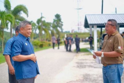 Azman (kiri) ketika penyerahan notis larangan menduduki tanah kerajaan tanpa kebenaran di salah satu ladang FGV di Terengganu pada Ahad. Foto Facebook Azman Ibrahim