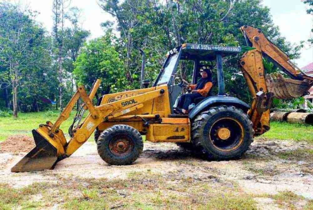 Aksi selamba Nik Nur Damia Batrisyia mengemudi jengkaut di Kampung Padang Bemban, Binjai, Kota Bharu mencuri perhatian orang ramai apabila kemahirannya bukan sahaja pada pemanduan, malah turut mahir membaiki jentera berat. Foto: SINAR HARIAN/HAZELEN LIANA KAMARUDIN

