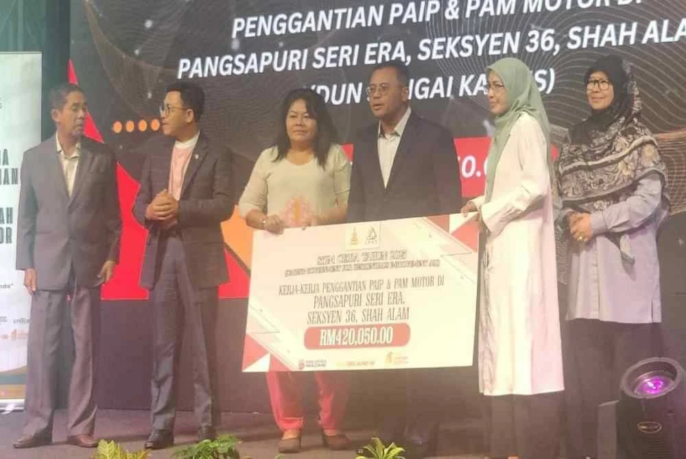 Amirudin (tiga dari kanan) menyampaikan replika cek simbolik kepada wakil penduduk sempena Majlis Pemberian Bantuan Projek Skim Ceria Tahun 2025 di sini pada Selasa.