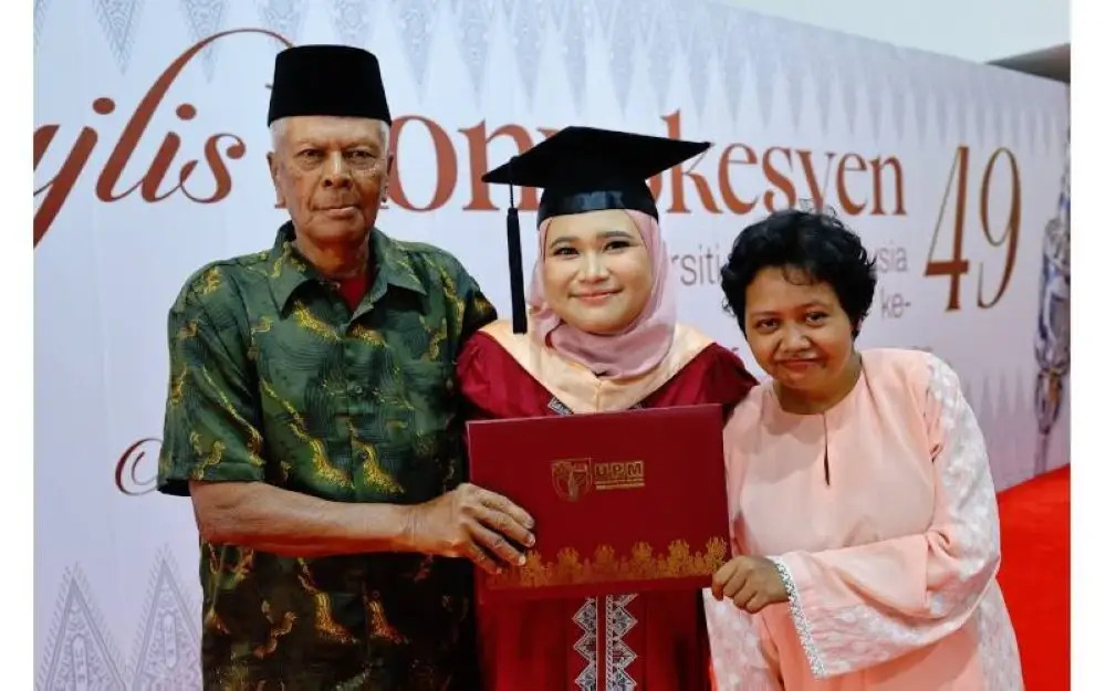 Elie (tengah) meraikan kejayaan bersama ayah dan kakaknya pada Majlis Konvokesyen UPM ke-40 di UPM, Serdang.