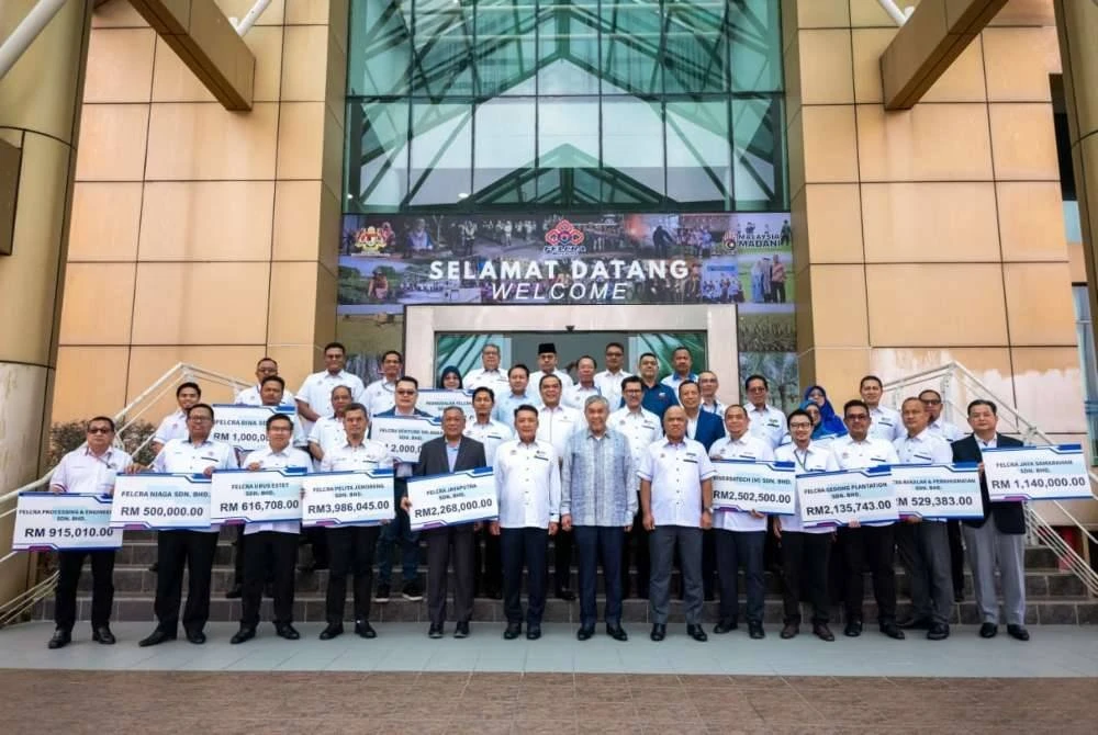 Ahmad Zahid (berdiri tengah) bergambar bersama selepas menyempurnakan Majlis Penyampaian Dividen Subsidiari dan Syarikat Bersekutu FELCRA Berhad pada Selasa