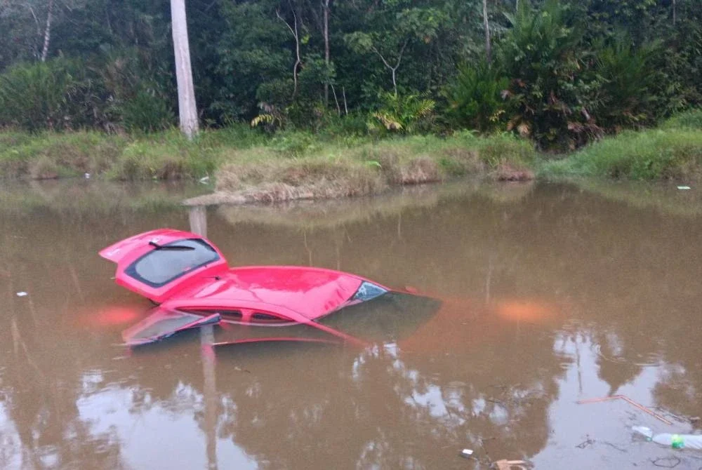 Kereta dinaiki mangsa hilang kawalan sebelum terbabas ke dalam tasik di bahagian kanan jalan. Foto: PDRM