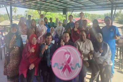 Irmohizam (duduk depan, tiga dari kanan) dan Dr Magendra (duduk depan, dua dari kiri) bergambar bersama peserta dan kakitangan Hospital Metro sempena Program Women’s Voices, Women’s Choices: Cervical and Breast Cancer Awareness di Kampung Api-Api di sini pada Isnin.