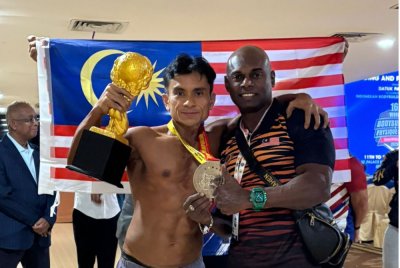 Sam (kiri) bergambar bersama jurulatih kebangsaan, Mike Mahen selepas meraih perak di Kejuaraan Dunia Bina Badan ke-16 di Batam, Indonesia baru-baru ini.