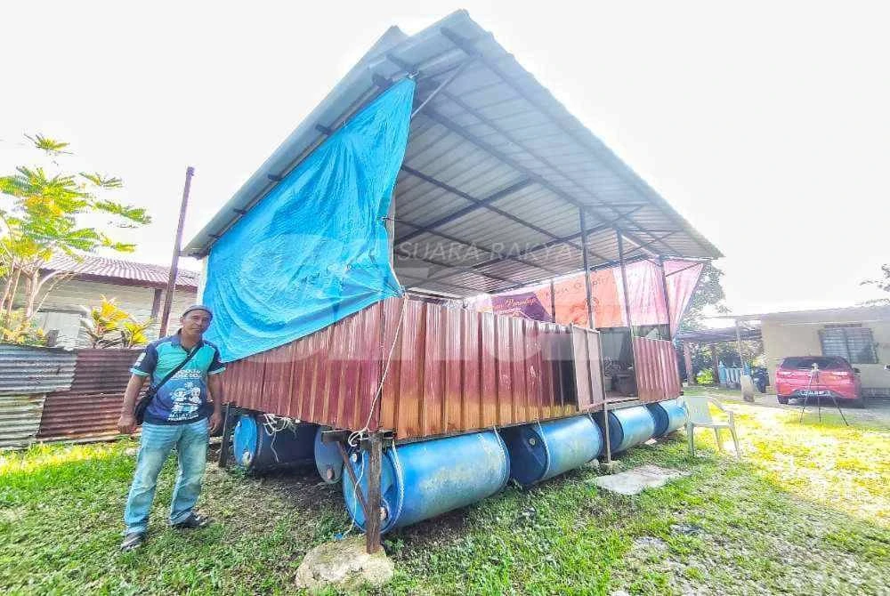 Husain menunjukkan rumah rakit yang dibina berdekatan rumah bagi menyelamatkan pelbagai barangan rumah daripada musnah setiap kali musim tengkujuh di Kampung Telok Mahang berhampiran Sungai Belat di sini pada Rabu. - Foto Sinar Harian