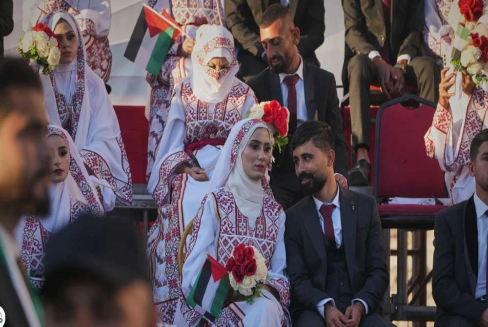 Pasangan Palestin, Hikmat Lawwa dan Eman Lawwa menyertai pengantin-pengantin lain dalam upacara perkahwinan beramai-ramai di Hamad City, Khan Younis, selatan Genting Gaza, pada Selasa.-Agensi