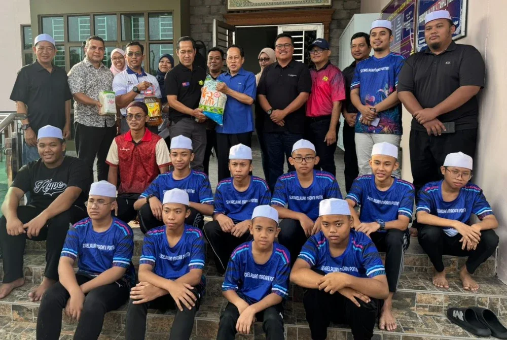 Ahmad (berdiri, tujuh dari kanan) bersama ahli-ahli Kelab Sukan dan Kebajikan JKR Johor di Madrasah Thafiz Pendita Madani, di Kampong Parit Yusof, Benut, Pontian pada Khamis.