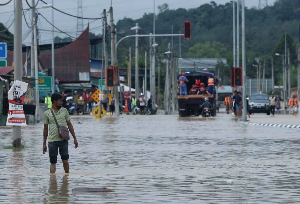 Penduduk kampung meranduk banjir yang menenggelamkan jalan utama Hulu Langat di Kampung Sungai Serai. - Bernama