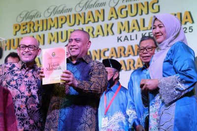 Abdul Aziz (kiri) mengiringi Saarani (dua dari kiri) ketika menyempurnakan gimik perasmian buku Tokoh Mubarak sempena Majlis Makan Malam sempena Perhimpunan Agung Tahunan Mubarak kali ke-22 pada Rabu.
