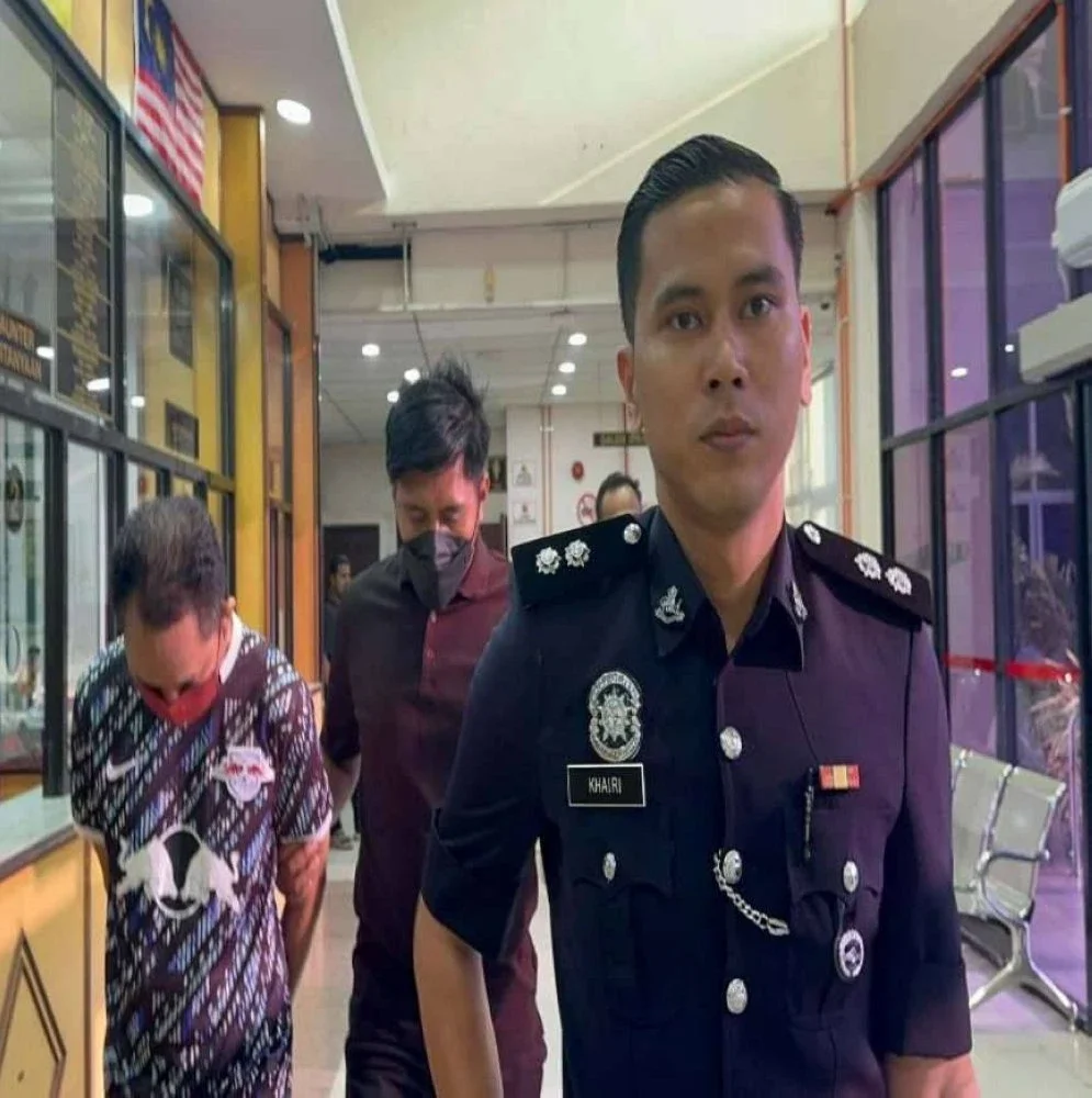 Tertuduh (kiri) diiringi anggota polis ketika dibawa ke Mahkamah Butterworth pada Jumaat.
