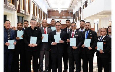 Steven Sim (tengah) mempamerkan RUU Akta Keselamatan Sosial Pekerja 2025 (Pindaan) atau Akta 4 yang diluluskan di Dewan Rakyat pada Selasa.