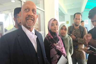 Ummu Haiman Bee (dua dari kiri) hadir ke Mahkamah Tinggi Shah Alam pada Jumaat bersama ahli keluarga dan peguamnya (kiri).