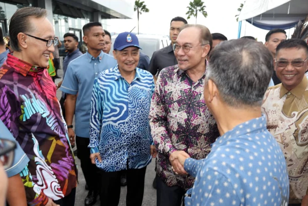 Hajiji (tiga dari kiri) mengiringi Anwar (tiga dari kanan) semasa menghadiri Majlis Sentuhan Madani Bersama Rakyat Negeri Sabah di SICC, Kota Kinabalu pada Sabtu. 