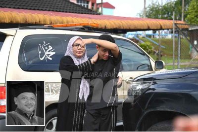 Anak Allahyarham Hassan (gambar kecil) tidak dapat menahan sebak sebaik jenazah dikeluarkan dari Unit Forensik Hospital Hulu Terengganu untuk dibawa pulang dan dikebumikan di Kelantan.
