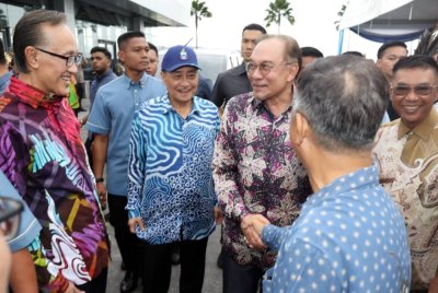 Hajiji (tiga dari kiri) mengiringi Anwar (tiga dari kanan) semasa menghadiri Majlis Sentuhan Madani Bersama Rakyat Negeri Sabah di SICC, Kota Kinabalu pada Sabtu. 