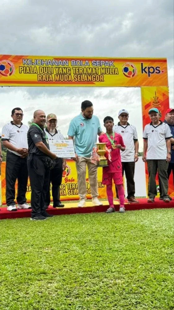 Muhammad Arif menerima trofi Piala Raja Muda Selangor B-12 daripada Tengku Amir.