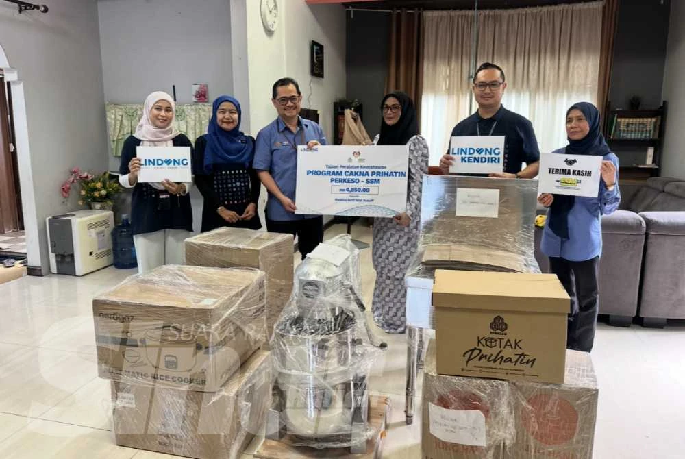 Simbolik penyerahan barangan oleh Mohd Zawawi (dua dari kiri) diiringi Nora (dua dari kiri) kepada Roslina (tiga dari kiri). 