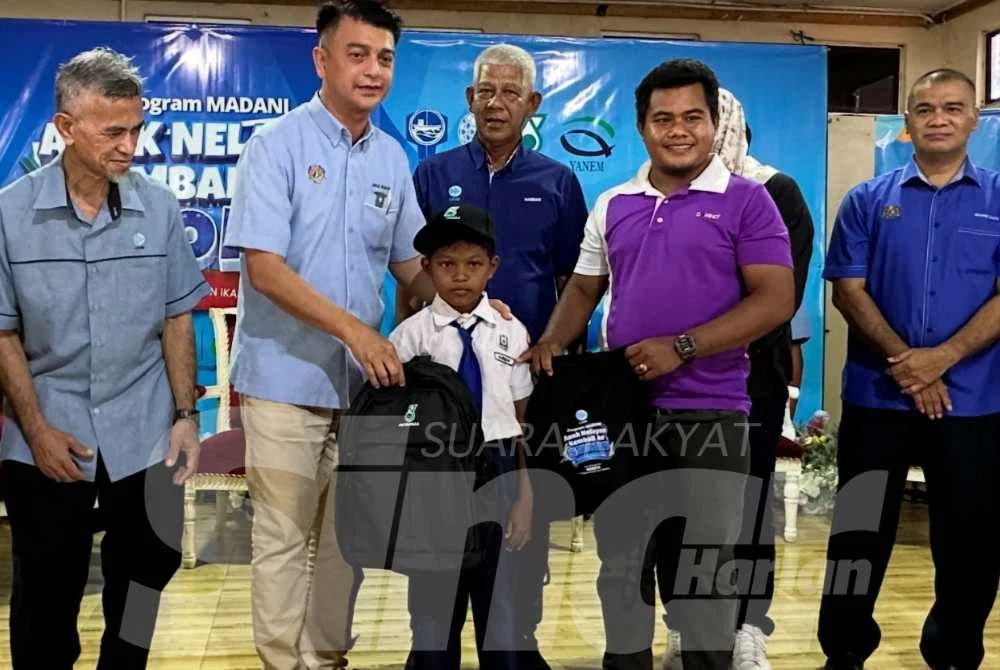 Mohamad Khairul (dua dari kiri) bersama anaknya menerima sumbangan beg sekolah disampaikan oleh Muhammad Faiz (dua dari kiri). - Foto: SINAR HARIAN/ADILA SHARINNI WAHID