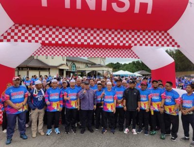 Nik Ibrahim (depan, tiga dari kiri) bergambar bersama tetamu kenamaan dan para peserta sebelum pelepasan Program Briskwalk Keluarga Rakan Muda Aktif Masjid Bilangan 3 Peringkat Daerah Jengka pada Sabtu