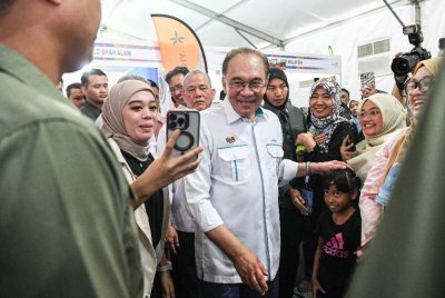 Anwar (tengah) beramah mesra bersama pengunjung ketika melawat ke reruai pameran selepas Majlis Perasmian Penutupan Program Rancakkan Madani Bersama Malaysiaku Tahun 2025 di Dataran Putrajaya pada Ahad. Foto Bernama