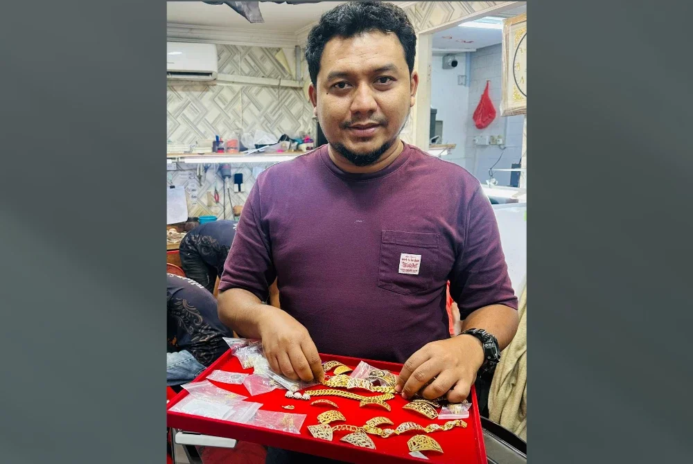 Wan Hafizuddin menunjukkan produk emas di kedainya.