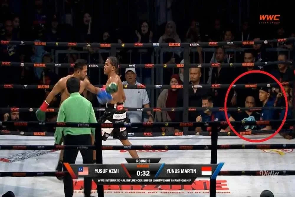 Cornerman Yusuf Azmi (dalam bulatan merah) bersiap sedia dengan tuala sebelum melemparkannya ke dalam gelanggang sebagai tanda menyerah kalah di penghujung pusingan ketiga. 