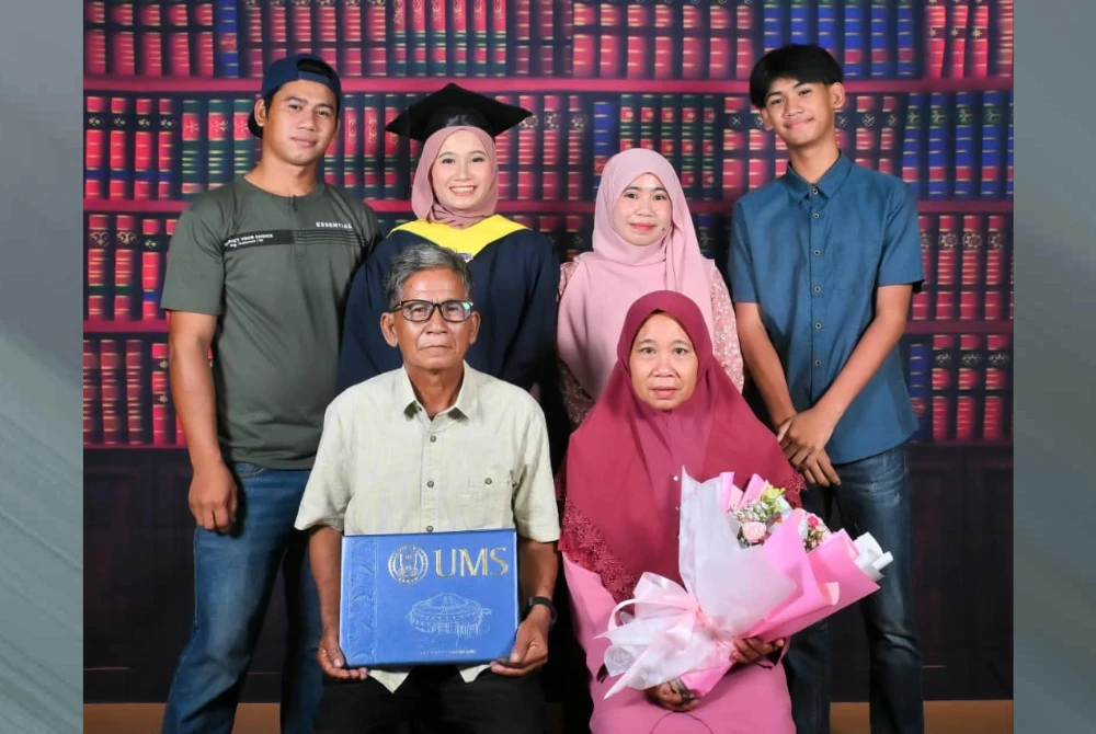 Marni (belakang, dua dari kiri) bersama keluarganya bergambar kenangan selepas upacara Majlis Konvokesyen UMS ke-27 di Kota Kinabalu.