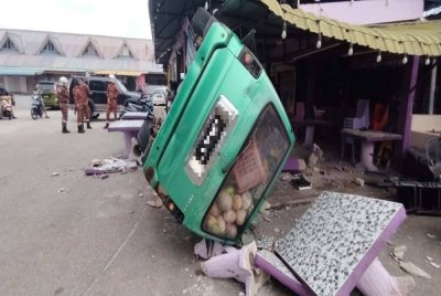 MPV jenis Toyota Unser dalam keadaan hampir terbalik selepas melanggar tiang kedai makan di Kampung Kuala Pahang, di sini pada pagi Isnin. Foto Bomba Pahang.