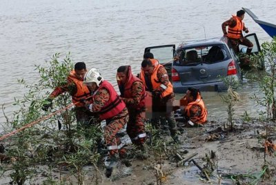 Anggota bomba membawa keluar mangsa dari MPV. - Foto BBP Muar