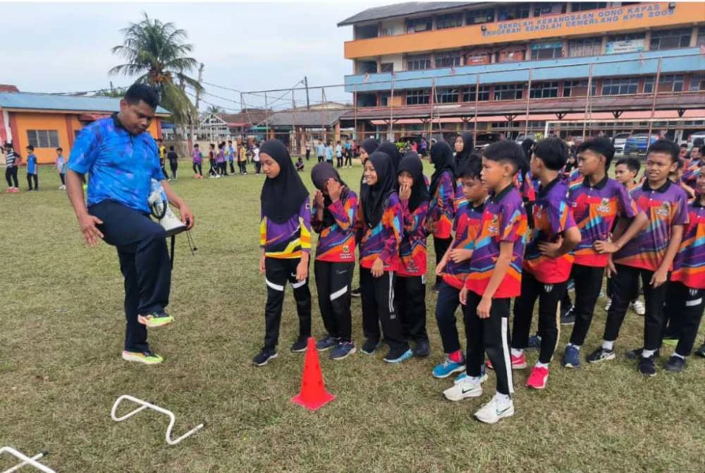 Nazmizan (kiri) ketika mengendalikan klinik Olahraga Perdana Peringkat Negeri Terengganu di Sekolah Kebangsaan (SK) Gong Kapas pada Oktober lalu.