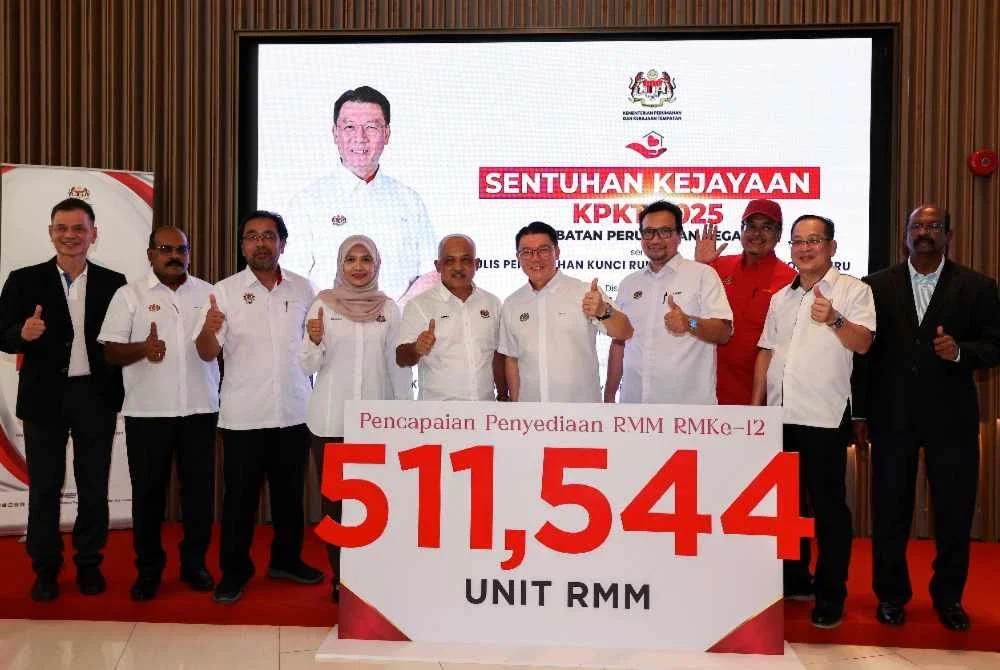 Kor Ming (lima, kanan) menunjukkan replika jumlah pencapaian penyediaan RMM RMK12 pada Majlis Penyerahan Kunci Rumah Vista Tiara pada Selasa. Foto Bernama